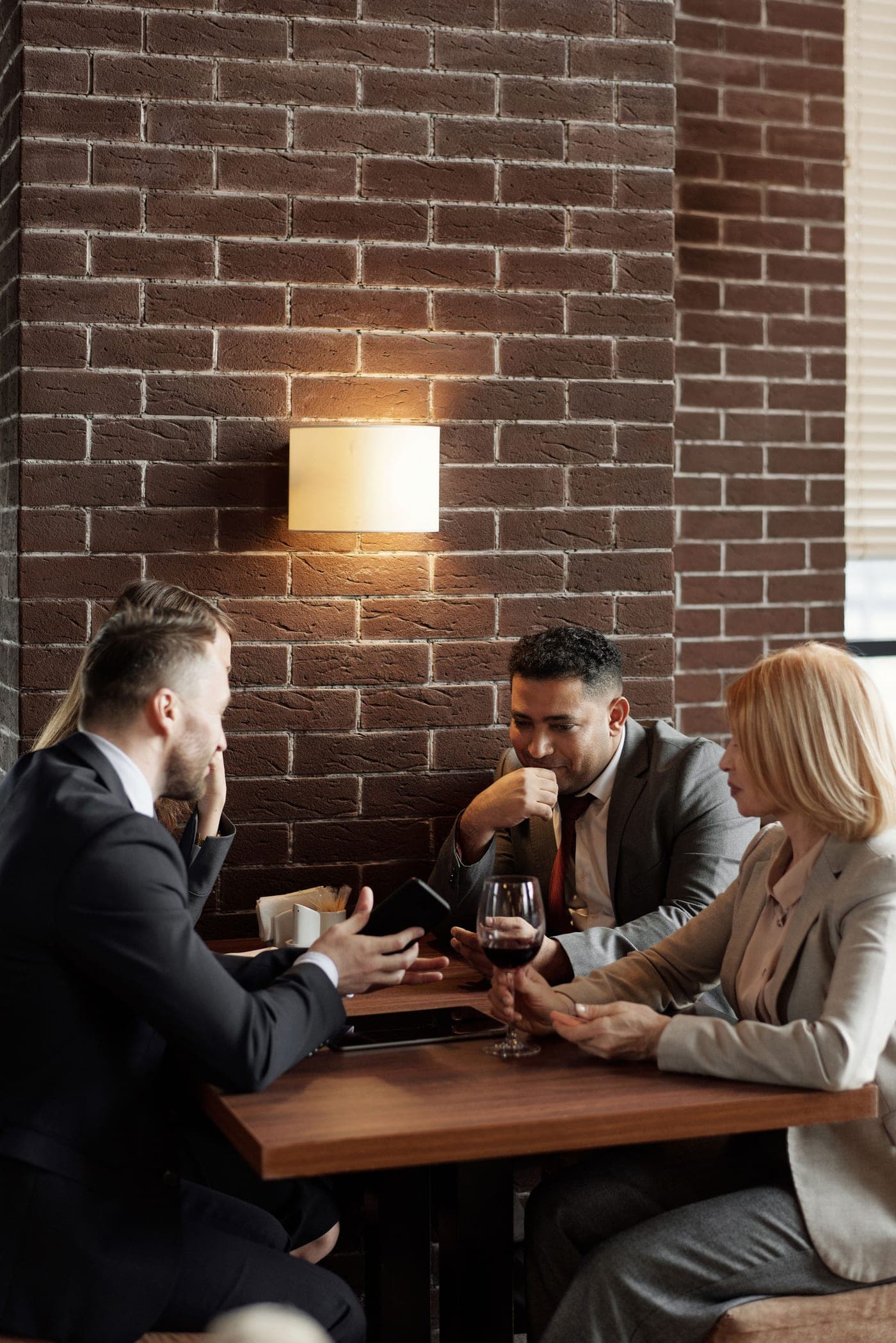 Three colleagues in suits talking across a table